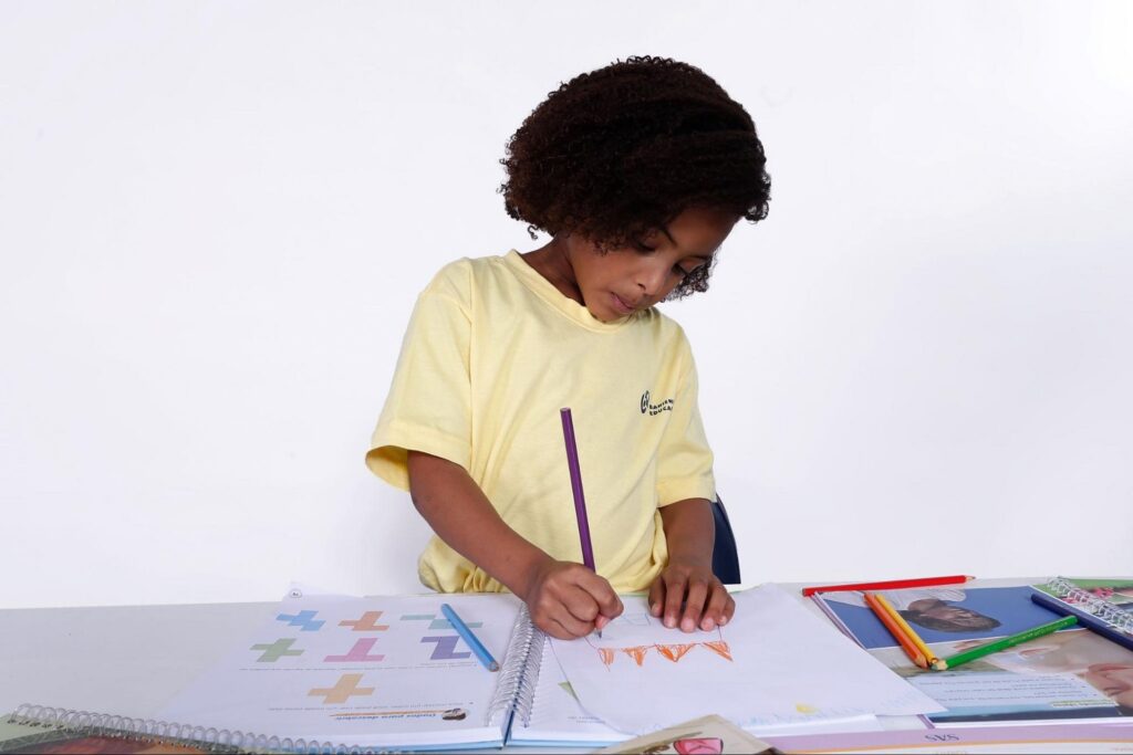 Menina escrevendo e estimulando seu desenvolvimento cognitivo infantil