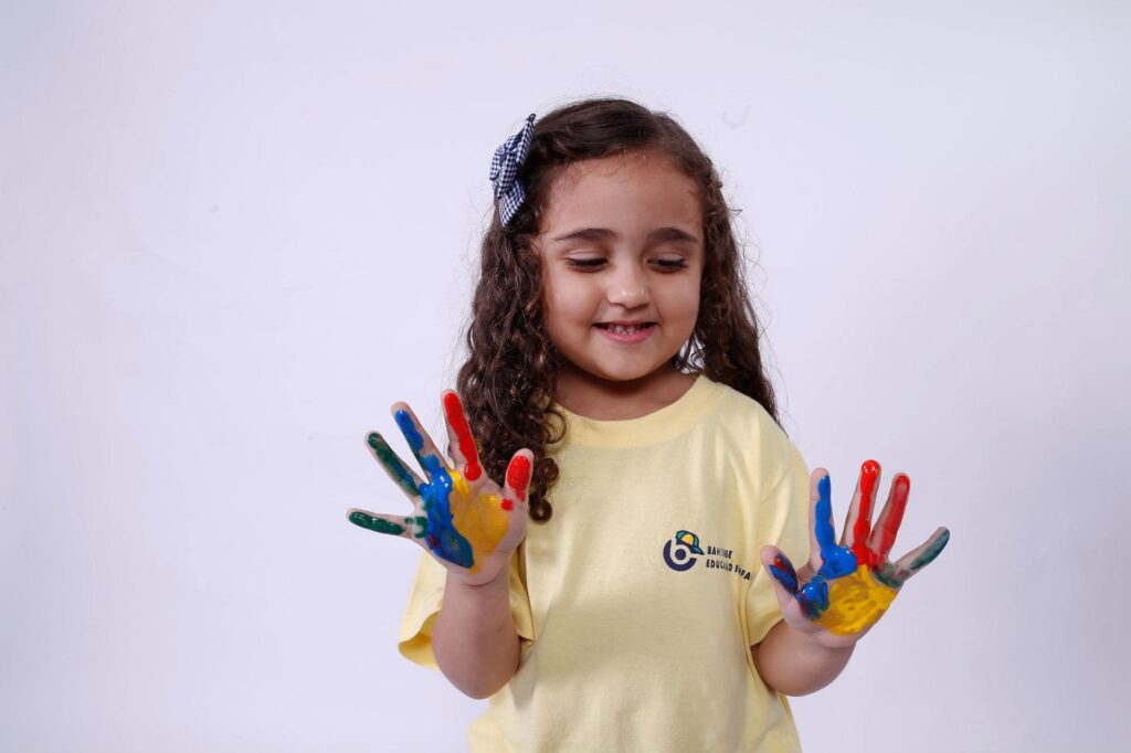 menina brincando com tintas para estimular o desenvolvimento infantil