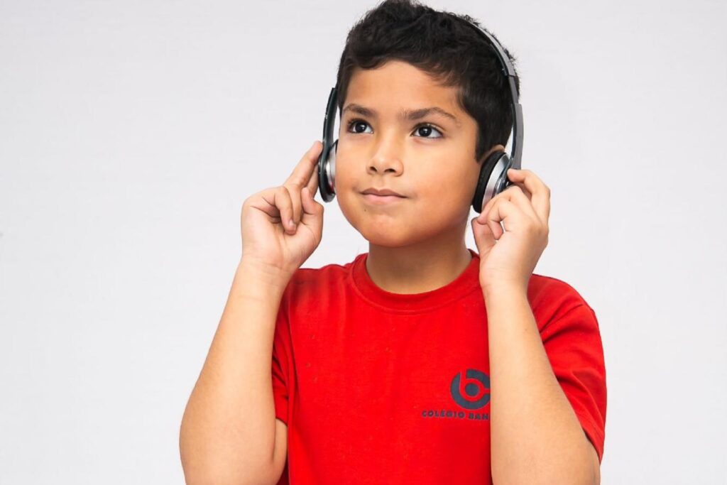 menino escutando música para aprender inglês em casa