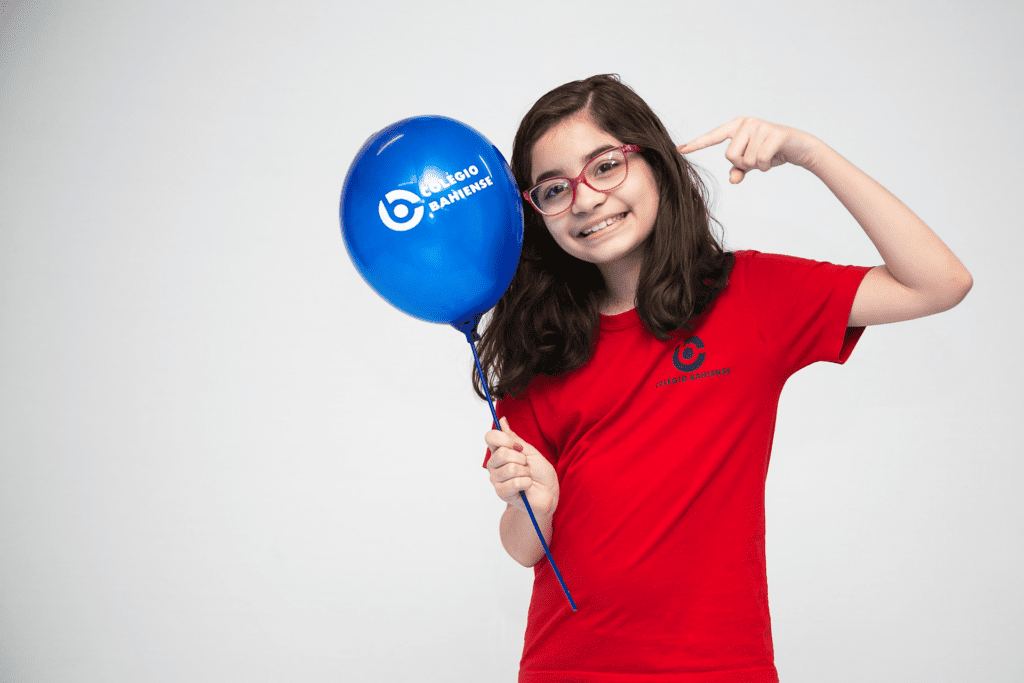 menina segurando balão com logotipo do Colégio Bahiense