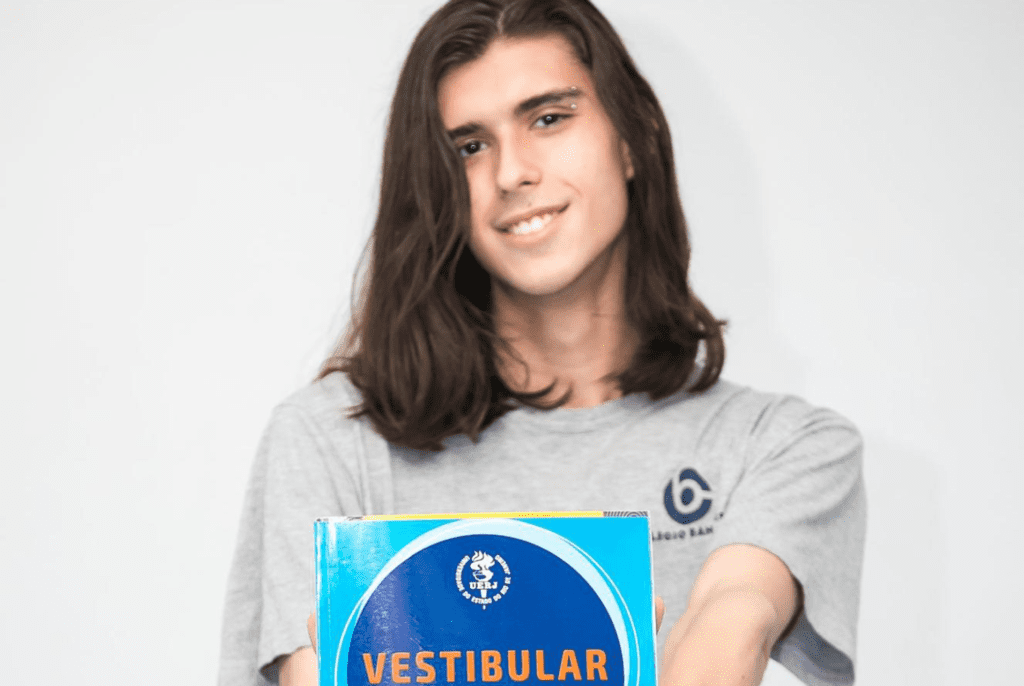 Aluno segurando livro para passar no vestibular