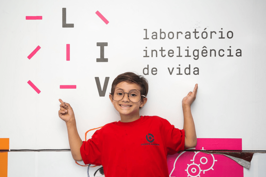 Aluno do Colégio Bahiense em frente ao banner de “Laboratório Inteligência de Vida”