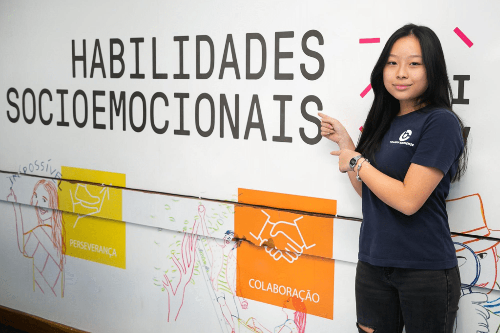 Adolescente em frente ao banner “habilidades socioemocionais”