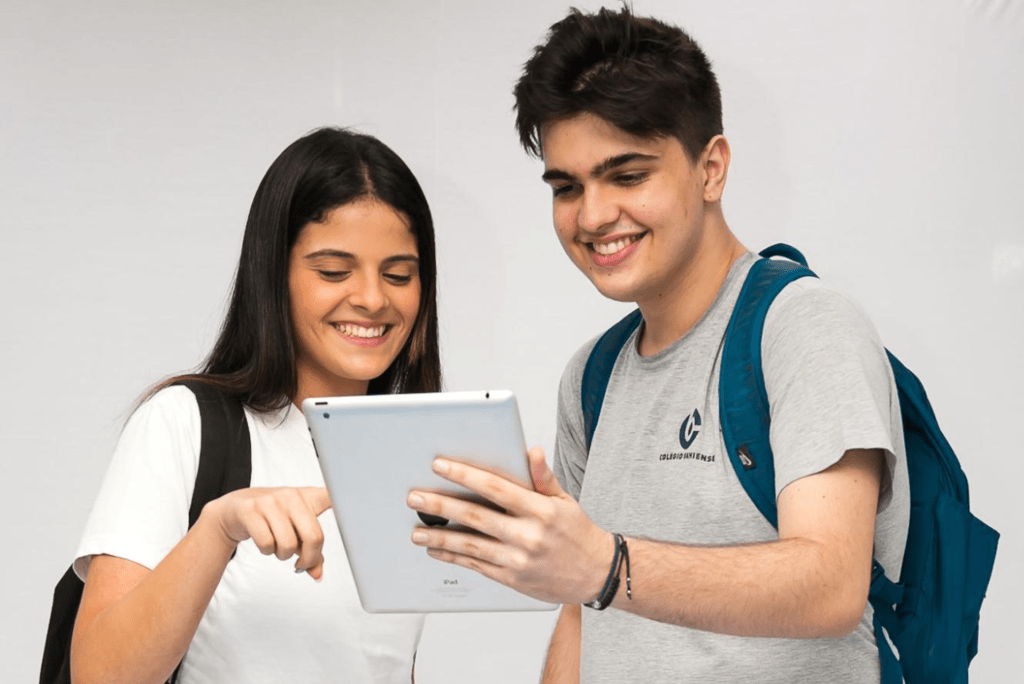 Menina e menino do Ensino Médio do Colégio Bahiense usando um tablet