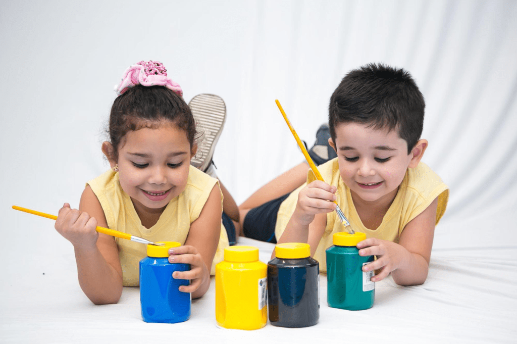 Crianças brincando de atividades lúdicas com tintas e pincéis