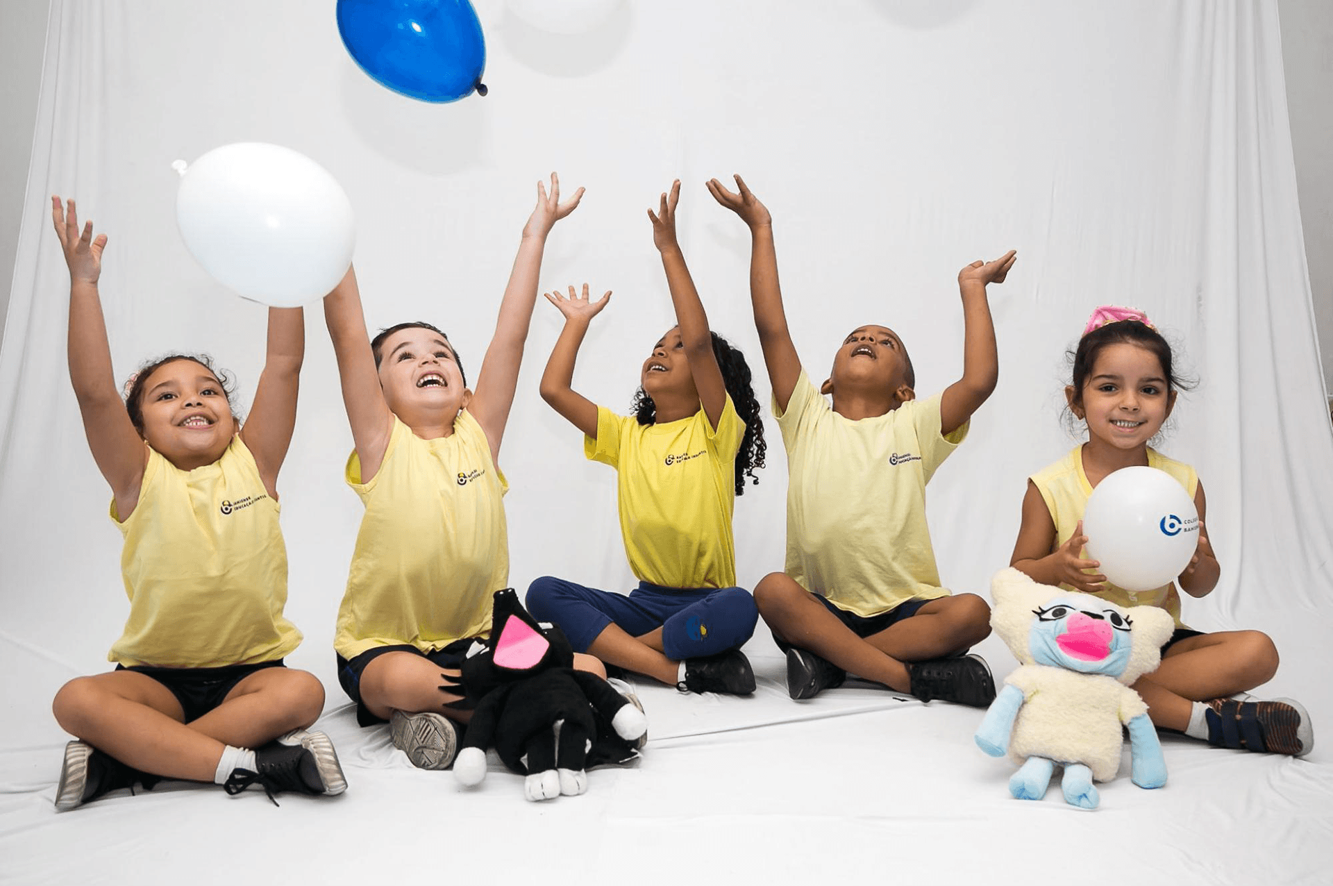 Crianças participando de atividades lúdicas com balões e bichos de pelúcia