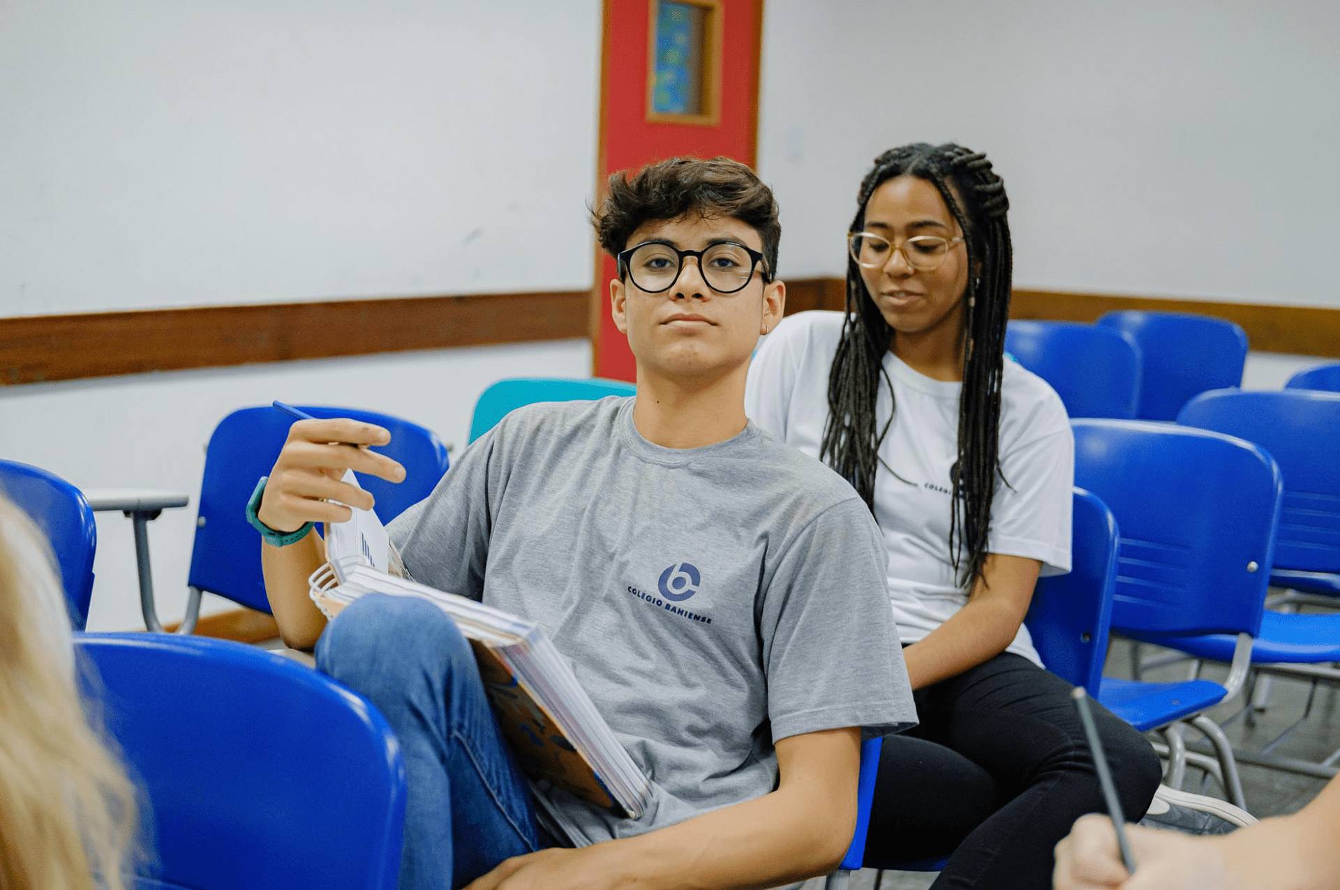 Aluno do Colégio Bahiense sentado em sala de aula olhando para a câmera