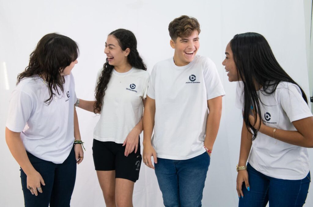 Alunos adolescentes do Colégio Bahiense uniformizados posando para foto enquanto conversam